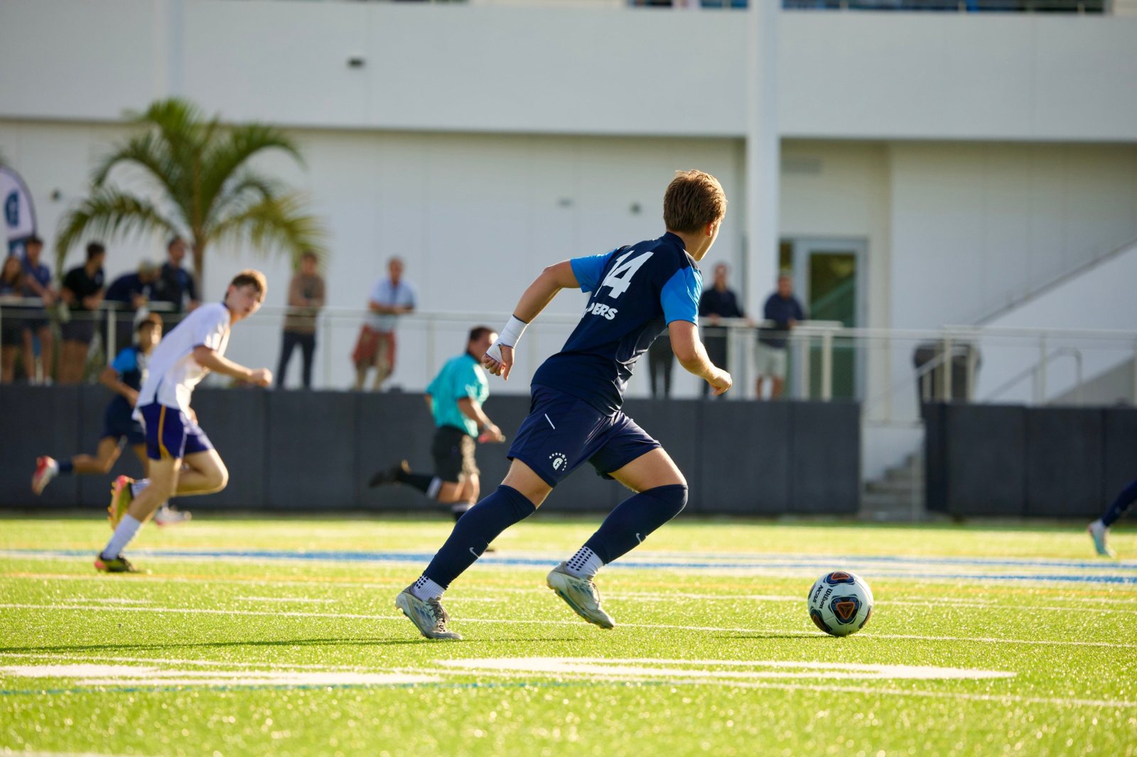 Gulliver No. 14 dribbling upfield in late-afternoon light