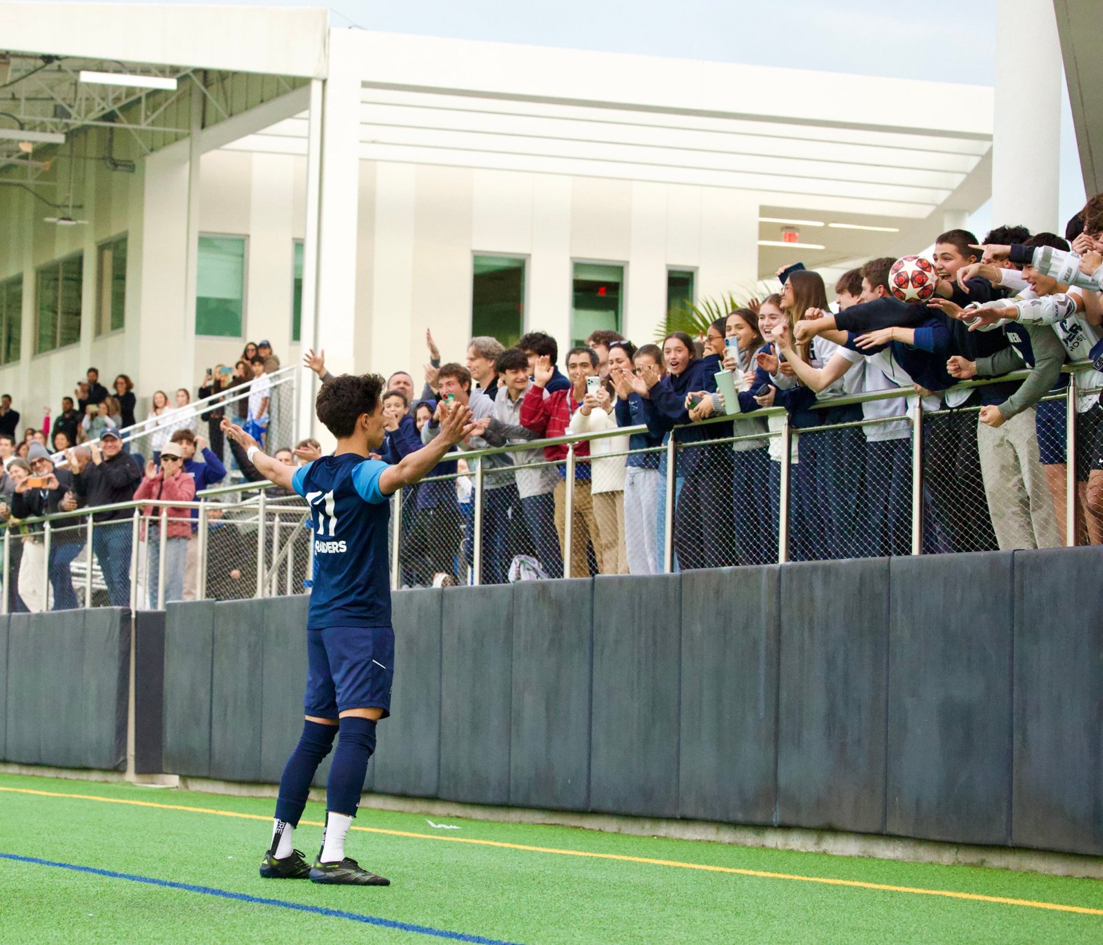 Gulliver No. 11 spreads his arms toward a cheering student section after a goal