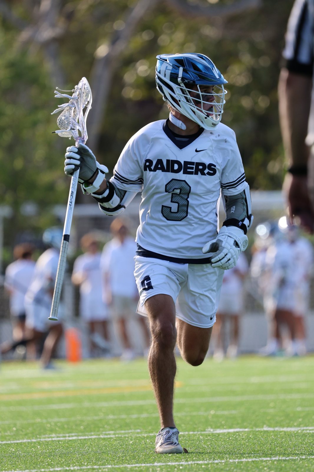 Gulliver lacrosse No. 3 running with his stick raised